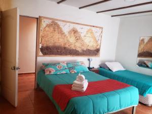 ein Schlafzimmer mit 2 Betten und einem Wandgemälde in der Unterkunft Katchi in San Pedro de Atacama