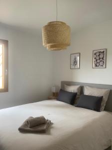 a bedroom with a large white bed with two towels on it at Appartement au centre de St Martin de Belleville in Saint-Martin-de-Belleville