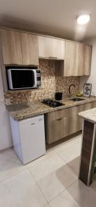 uma cozinha com um micro-ondas e um fogão forno superior em Peco Paradise Cumbuco Ap119 em Cumbuco