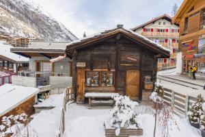 a small wooden building with snow on the ground at Yukon in Zermatt