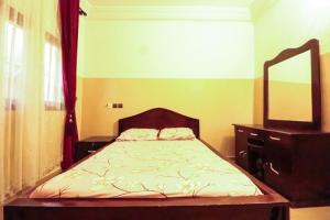 1 dormitorio con cama, tocador y espejo en Villa Nika en Lomé