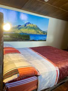 een slaapkamer met een schilderij van een berg aan de muur bij Blue house La Floresta in Quito