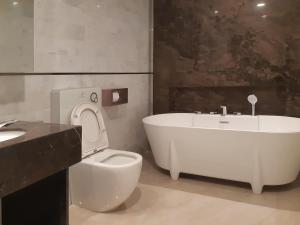 a bathroom with a tub and a toilet and a sink at ASTRA @ Suite Platinum 2 KLCC in Kuala Lumpur