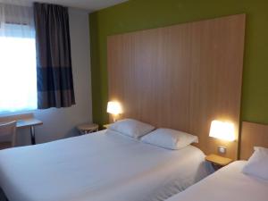 ペズナにあるB&B HOTEL Pézenasのベッド2台と窓が備わるホテルルームです。