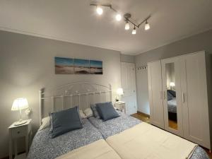 um quarto com uma cama grande e 2 almofadas azuis em Apartamentos Los Cubos de Llanes 1 em Llanes