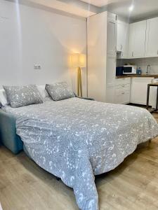 a bedroom with a bed and a kitchen at Estudio a 400 metros Ribera FREE PARKING in Córdoba