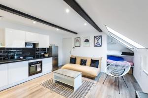 ein Wohnzimmer mit einem Sofa und einem Tisch in der Unterkunft Bienvenue à Reims type studio charmant et lumineux 2eme étage in Reims