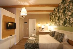 a bedroom with a bed and a flat screen tv at Dolphin Park Hotel in Ortaca
