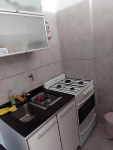 a small kitchen with a stove and a sink at Relax en Palermo con gran balcon y wifi 300MB in Buenos Aires