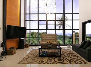 tagaytay transient ph في تاجيتاي: غرفة معيشة مع كرسي ونافذة كبيرة