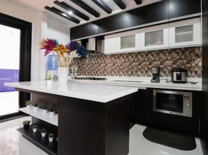 a kitchen with a white counter and a microwave at tagaytay transient ph in Tagaytay