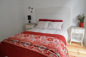 1 dormitorio con 1 cama con edredón rojo y blanco en Oporto Almada 329, en Oporto