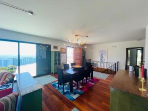 a dining room and living room with a table and chairs at Villa Camacho xxvii in Arco da Calheta