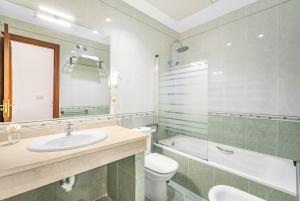 a bathroom with a sink and a toilet and a tub at Don Juan Beach Resort in Estepona