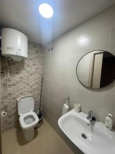 a bathroom with a sink and a toilet and a mirror at Apartamento Coman Av Rey Juan Carlos I in Torrent