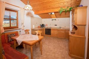 a kitchen with a wooden table and a kitchen with a couch at Bauernhof Daurerhof in Aschau im Chiemgau