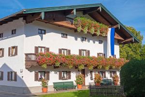 um edifício com flores ao lado em Bauernhof Daurerhof em Aschau im Chiemgau