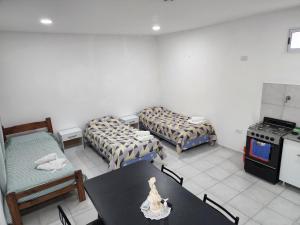 Habitación con 2 camas, mesa y fogones. en Monoambiente en el centro de la Ciudad., en Mercedes