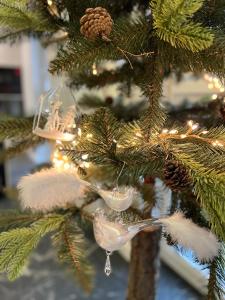 Un árbol de Navidad con un adorno de pájaro. en Apartament Primavera 2 z Sauną i Jacuzzi en Kielce