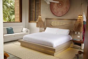 a bedroom with a white bed and a couch at Casa Origen in Los Naranjos