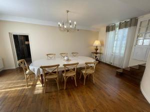 une salle à manger avec une table et des chaises blanches dans l'établissement La Jasoupe, à Demigny