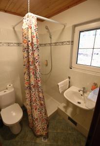 a bathroom with a shower curtain with a toilet and a sink at Apartmány Jakub in Belá