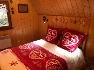 a bed with red and white blankets and pillows in a room at Chalet Le Cerf in Wildersbach