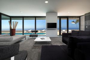 a living room with a couch and a tv at Atlantic Luxury Veranda in Calheta