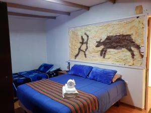 Schlafzimmer mit einem Bett mit Wandgemälde in der Unterkunft Katchi in San Pedro de Atacama