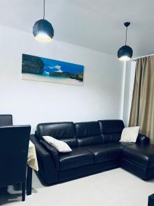 a black leather couch in a living room with two lights at Apartamento Coman Av Rey Juan Carlos I in Torrent