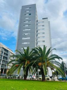 two palm trees in front of a tall building at Apartamento Coman Av Rey Juan Carlos I in Torrent