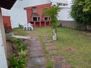 un camino de piedra que conduce a una casa con una mesa en Departamento Rebagliatti 170 en La Lucila del Mar