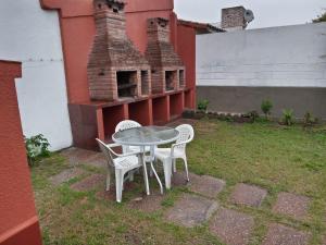 una mesa y sillas en un patio con chimenea en Departamento Rebagliatti 170 en La Lucila del Mar