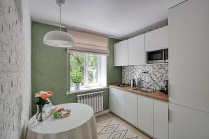 a kitchen with a white table and a window at апартаменты Djent-house in Almaty