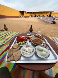 een dienblad met eten op een tafel met eten erop bij Arafa Nubian Guest house in Aswan
