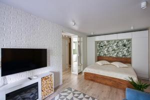 1 dormitorio con 1 cama y TV en una pared de ladrillo en апартаменты Djent-house en Almaty