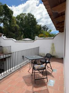 a table and chairs on a patio with a fence at Casa Anabel in Antigua Guatemala