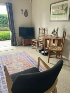 a living room with a table and a chair at Rabbit Wardens Cottage in Queensberry
