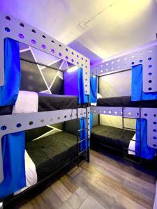 two bunk beds in a room with blue lighting at ROOMIES HOSTEL Parque México in Mexico City