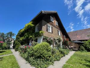 a house with flowers on the side of it at Bodensee Apartments, Sauna, Lake Walks, Free Parking, Self Checkin, Nature Reserve, Restaurants Nearby in Gaißau
