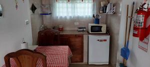 une petite cuisine avec une table et un four micro-ondes dans l'établissement Ayres Serranos, à Merlo