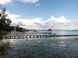 a pier on the beach with people on the water at Mi Cuartito en Bacalar in Bacalar