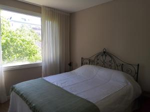 1 dormitorio con cama y ventana grande en Departamento con vista en San Carlos de Bariloche