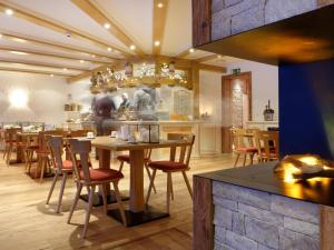 a restaurant with tables and chairs and a counter at Hotel Plateau Rosa in Zermatt