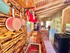 een keuken met een houten muur met potten en pannen bij Cabaña Recordando El Ayer in San Lorenzo