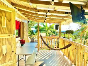 een houten veranda met een tafel en een hangmat bij Cabaña Recordando El Ayer in San Lorenzo