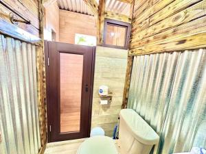 a bathroom with a toilet and a wooden wall at Cabaña Recordando El Ayer in San Lorenzo