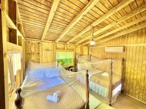 um quarto com 2 camas num chalé de madeira em Cabaña Recordando El Ayer em San Lorenzo