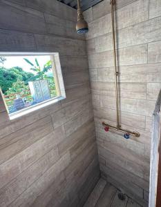 y baño con ducha y ventana. en Cabaña Recordando El Ayer en San Lorenzo