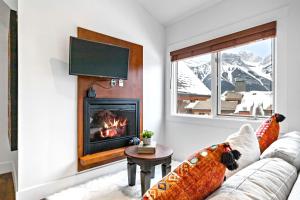 a living room with a couch and a fireplace at LUXE Penthouse with Mountain Views Solar A Resort & Spa in Canmore